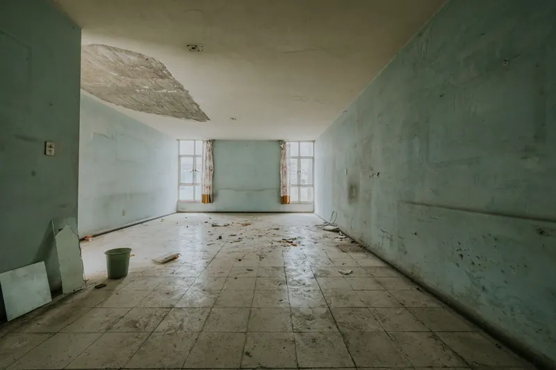 Pièce vide aux murs et au plafond marqués par l'humidité