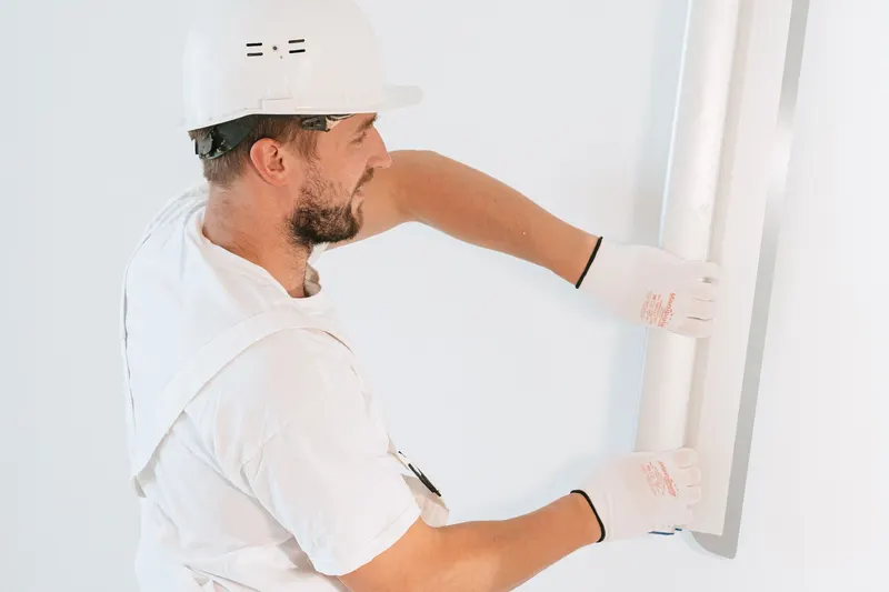 Plaquiste casqué posant une plaque lors de la remise en état