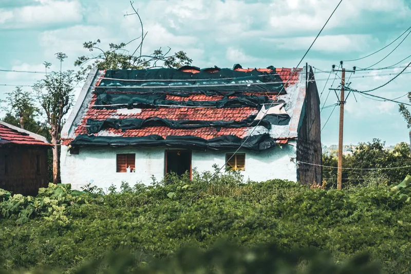 Toiture endommagée couverte de bâches de protection pour mettre la maison hors d'eau