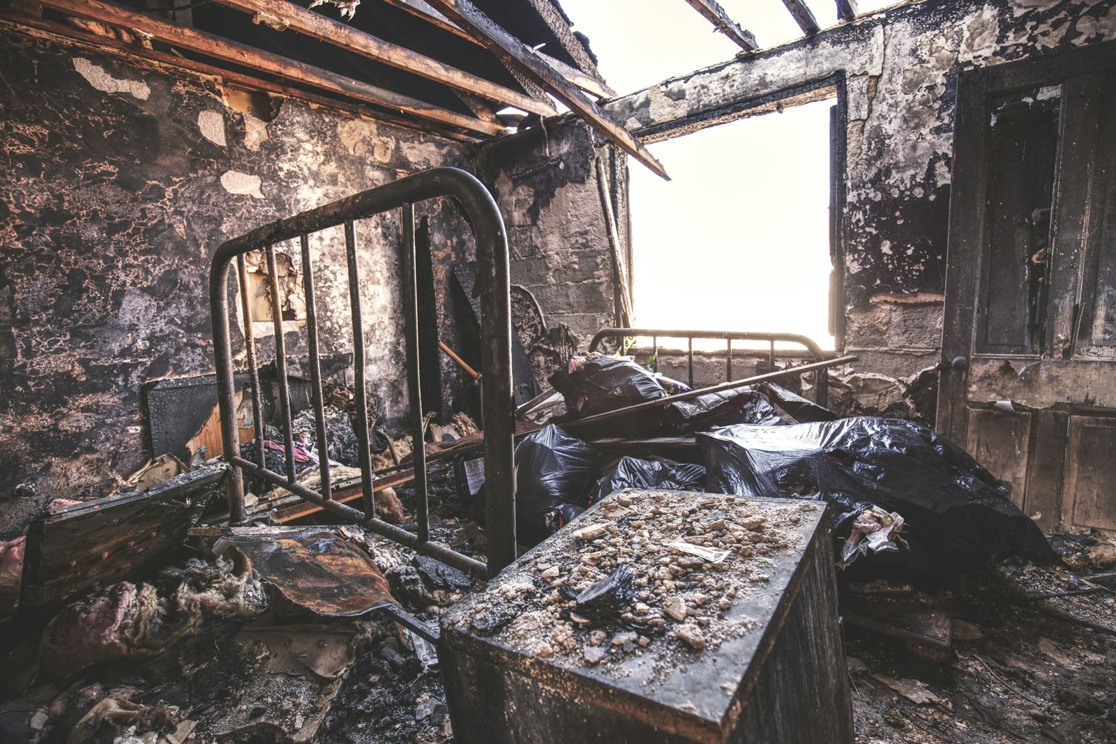 Chambre noircie par la suie après un incendie, avant décontamination